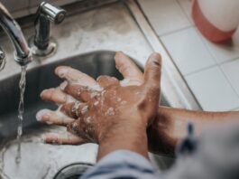 person in white shirt washing hands