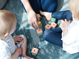 two toddler playing letter cubes