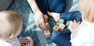 two toddler playing letter cubes