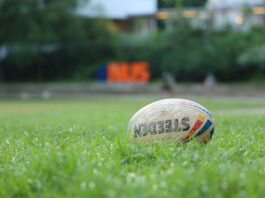 white and red soccer ball on green grass field during daytime