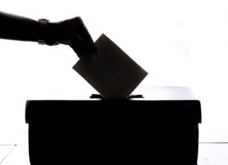 a person is casting a vote into a box