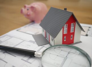 white and red wooden house beside grey framed magnifying glass