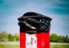 red and black trash bin on green grass field during daytime