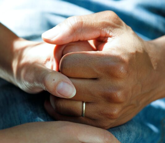 person wearing gold wedding band