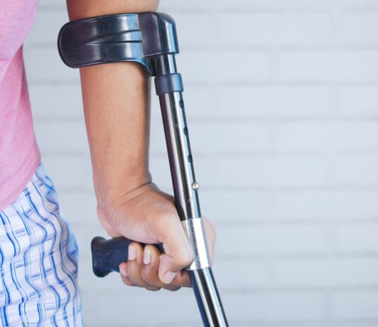 a person holding a crutch and walking cane